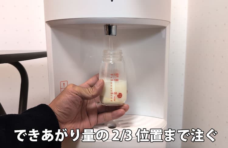 粉ミルクを入れた哺乳瓶の3分の2位置までHOT ECO温水を注ぐところ