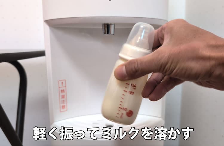 粉ミルクを入れた哺乳瓶にHOT ECO温水を2/3量入れて軽く振って溶かしているところ