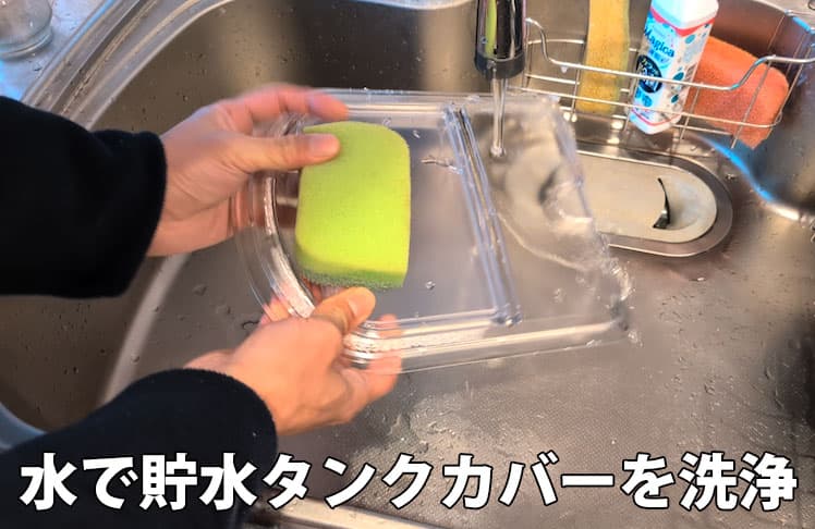 エブリィフレシャス・ライトの貯水タンクカバーを水で洗浄しているところ